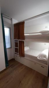 阿利坎特VAD HOSTEL ALICANTE的客房设有两张双层床和一扇窗户。