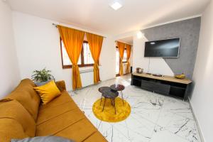 萨拉热窝Hedonist Spa Apartment的客厅配有沙发和桌子