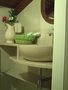 Mendiga丽池利迪娅酒店 - 图力士姆的浴室里装有碗和花瓶的架子