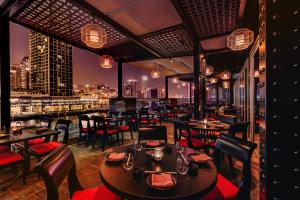 迪拜Grand Millennium Business Bay的一间带桌椅的餐厅,享有城市天际线
