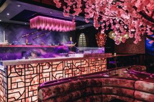 迪拜Grand Millennium Business Bay的天花板上挂着粉红色花的酒吧
