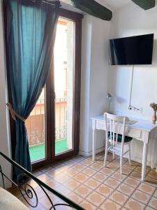 PieraLa Casa Vella EL BEDORC的客房设有桌子和带书桌的窗户。