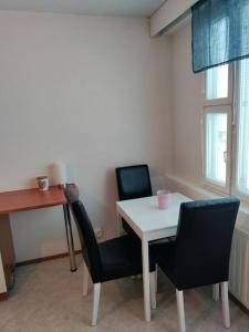 黑诺拉Toimiva kodikas yksiö的配有桌子、两把椅子和一张书桌的房间