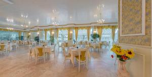 阳光海滩梅纳皇宫酒店 - 全包的一间带桌椅和鲜花的用餐室