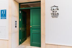 奇克拉纳－德拉弗龙特拉CASA DE LA VEGA SUITES的建筑中带有标志的绿色门