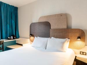 马赛B&B HOTEL Marseille Prado Parc des Expositions的酒店客房,配有一张带床头板的床