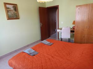 热尼亚波尔萨瓦Family apartments "Hamster" up to 7 persons的一间卧室配有一张橙色大床和两条毛巾