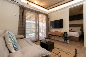 阿约斯尼奇塔斯Junam Private Beachfront Cabins的客厅配有沙发和1张床