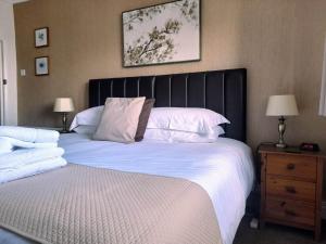 圣艾夫斯瑟乐斯通旅馆的一间卧室配有一张大床和黑色床头板