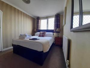 圣艾夫斯瑟乐斯通旅馆的一间卧室设有一张大床和两个窗户。