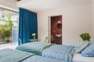 迪克斯梅德Het Oplaadpunt bed, bike, hike, 4-8 p的一间卧室设有蓝色的床和窗户。
