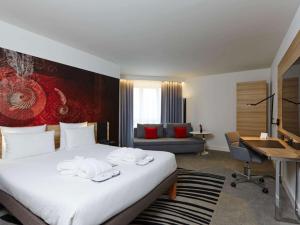 慕尼黑慕尼黑诺沃特酒店的配有一张床和一张书桌的酒店客房
