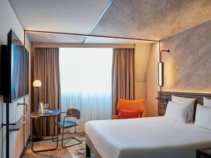 慕尼黑慕尼黑诺沃特酒店的酒店客房,配有床、桌子和椅子