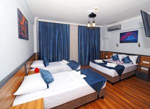伊斯坦布尔Arges old city hotel的两张位于酒店客房的床,配有蓝色窗帘