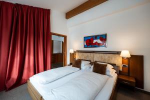 坎波图雷斯Feldmilla Design Hotel的一间卧室配有一张带红色窗帘的大床