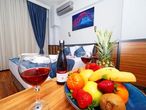 伊斯坦布尔Arges old city hotel的一张桌子,上面放着一盘水果和一瓶葡萄酒