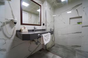 厄吕代尼兹Belcehan Hotel的一间带水槽、镜子和淋浴的浴室