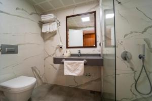 厄吕代尼兹Belcehan Hotel的一间带卫生间、水槽和镜子的浴室