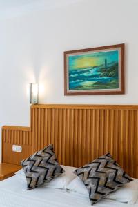 厄吕代尼兹Belcehan Hotel的一张带木头床头板和墙上照片的床