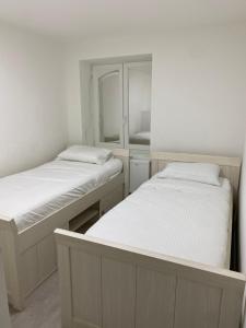 布鲁塞尔Appartement Deux chambres près de Atomium的带镜子的客房内的两张单人床