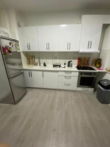 布鲁塞尔Appartement Deux chambres près de Atomium的厨房配有白色橱柜和冰箱。