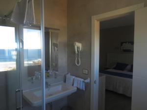 阿兰扎达Hotel Foxos的一间带水槽和淋浴的浴室以及一张床