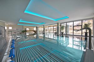 塔查斯卡-鲁穆尼卡Hotel SOREA URÁN的大楼内带蓝色灯光的大型游泳池
