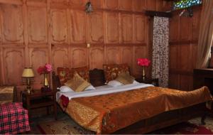 斯利那加Alif Laila Group of Houseboats, Srinagar的卧室配有木墙内的一张床