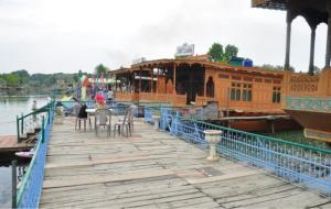 斯利那加Alif Laila Group of Houseboats, Srinagar的木甲板,水面上设有餐厅