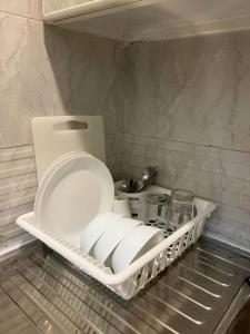 阿布扎比Luxury private Studio apartment close to Airport的冰箱里的架子,里面装了一些盘子