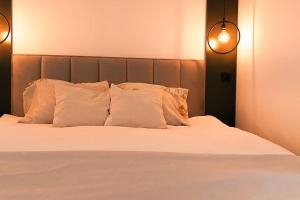 斯科普里The Modern Lodge的一张带白色枕头的床和两张灯
