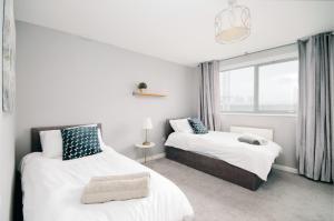 伦敦Stylish Apartment Close to London Bridge的一间卧室设有两张床和窗户。