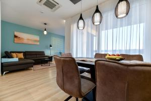 图兰杰CROWONDER Apartments & Rooms OAZA with heated Swimming Pool and Sauna的客厅设有餐桌和椅子