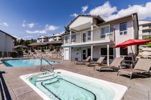 奇兰Park Pointe Lakeside Retreat A101的房屋前设有带热水浴池的游泳池
