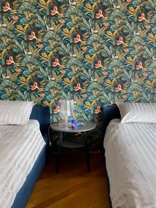 伊夫雷亚Il cantuccio的客房设有两张床和一张壁纸桌子。
