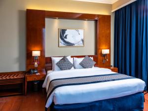 多哈艾尔瑞安瑞塔杰酒店的一间卧室配有一张带蓝色窗帘的大床