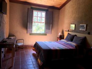 巴埃彭迪Pousada Condado Santa Maria的一间卧室设有一张床和一个窗口