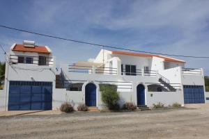 马约城Villa Sol e Mar - Vila do Maio - Ponta Preta的白色的房子,街上有蓝色的车库门