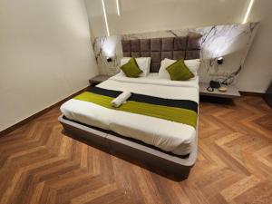 古尔冈Square9 - A Boutique Hotel的一间卧室配有一张带绿色和白色枕头的大床