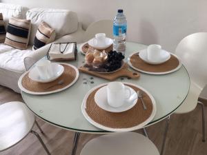 帕德隆Casa dos Cantares的配有帽子和盘子的玻璃桌和一瓶水