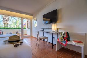 拉皮内达Oassium Hotel - Adults Only的客房设有一张床、一张桌子和一张书桌。