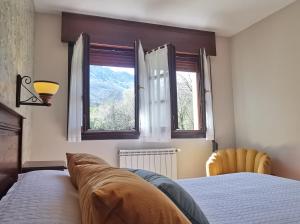 帕阿斯德兰斯埃尔吉迪奥乡村度假屋的一间卧室设有一张床和两个窗户。