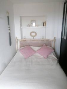 盖塔里Tamarina的一张带两个粉红色枕头的白色床