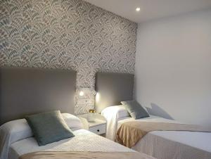 波尔托马林PortoSantiago Boutique & Rooms的一间卧室设有两张床和壁纸墙