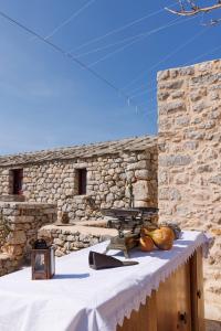 阿里奥波利斯Lithos Stone Suites的石墙前的桌子和野餐桌