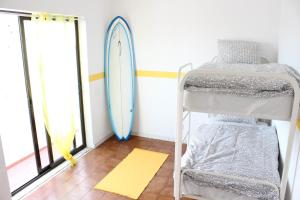 阿尔布费拉阿尔布费拉丰简旅馆的一间设有双层床的客房和壁挂式冲浪板