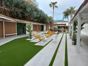 马尔格莱特德玛Sumus Hotel Monteplaya & SPA 4Sup - Adults Only的一个带椅子的庭院和绿色草坪