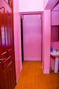 MaragoliCozier Domicile Apartments的粉红色的浴室设有水槽和门