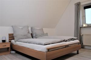 格洛米茨FEWO Ostseeland的一间卧室配有带白色床单和枕头的床。