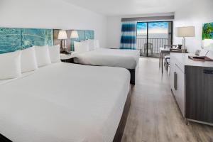 默特尔比奇热带海洋酒店 的酒店客房配有两张床和一张书桌
